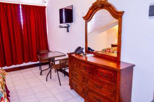 a bedroom with a dresser with a mirror on it at Fantastic Hotel in Marigot