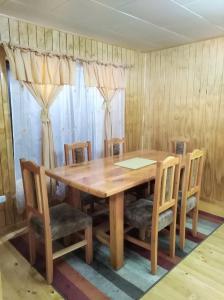 a dining room with a wooden table and chairs at Cabañas El Maitén in Castro
