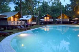 a large swimming pool in front of some resorts at Kottawatta Village in Udawalawe