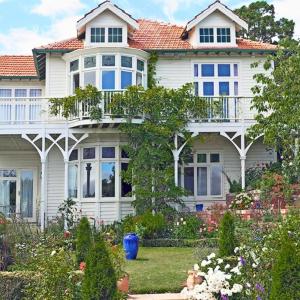 una gran casa blanca con un jardín delante de ella en Dyers House, en Christchurch