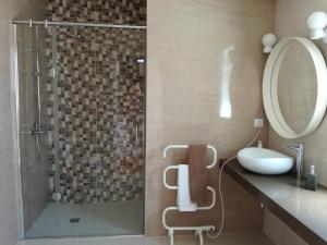 a bathroom with a shower with a sink and a mirror at Quinta Do Sol Poente in Feteiras