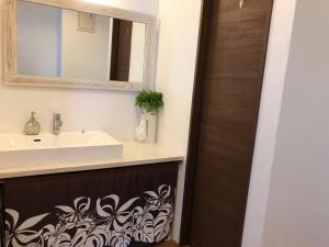 un bagno con lavandino e specchio di Guest room Halemakana ad Amami