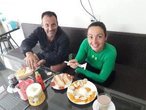 a man and a woman sitting at a table eating food at Venus Sapa Hostel in Sapa