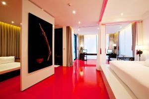 a bedroom with a white bed and a red floor at The Library - SHA Extra Plus in Chaweng