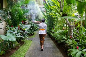 a woman standing in front of a fire hydrant spraying water at Jati Cottage in Ubud