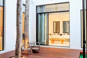 un soggiorno con tavolo e sedie su un pavimento in legno di The Library a Chaweng Beach
