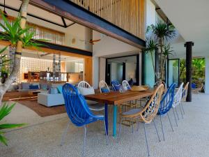 a dining room with a wooden table and blue chairs at Villa Seascape by Elite Havens in Nusa Lembongan
