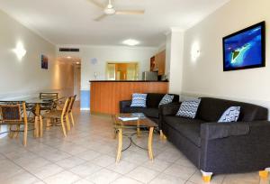 a living room with two couches and a table at Waterfront Terraces in Cairns