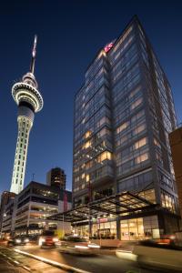 a large building with a tower in a city at Rydges Auckland in Auckland