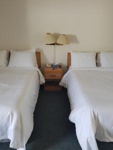 two beds sitting next to each other in a room at Covered Bridge Inn & Suites in Sussex