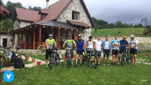 een groep mensen die voor een gebouw staan met hun fietsen bij Guesthouse Alpini in Lëpushë