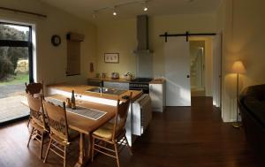 cocina y comedor con mesa y fregadero en The Woodsman's Den en Saint Arnaud