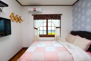 Ένα ή περισσότερα κρεβάτια σε δωμάτιο στο Gyeryonggil Pension