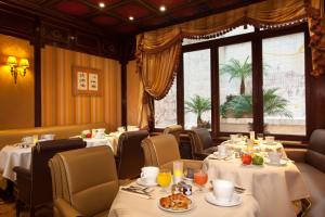 a restaurant with tables and chairs and a window at Hôtel Mayfair Paris in Paris