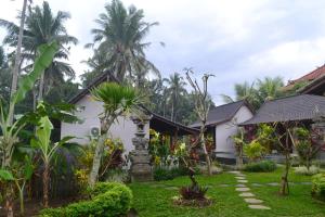 a garden in front of a house at Buda Cottage Ubud in Ubud