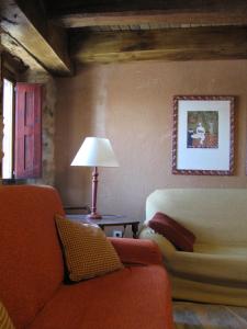 ein Wohnzimmer mit einem Sofa und einer Lampe in der Unterkunft Casa Rural Las Águedas in Murias de Rechivaldo