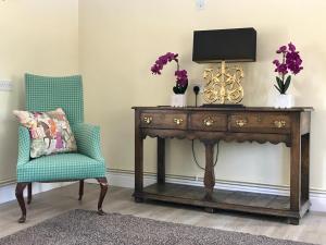 a table with a chair and a television on top at Seawell in Towcester