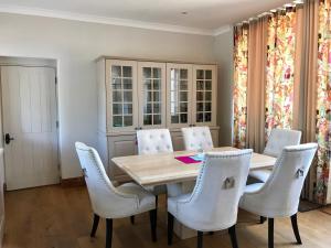 une salle à manger avec une table en bois et des chaises blanches dans l'établissement Seawell, à Towcester