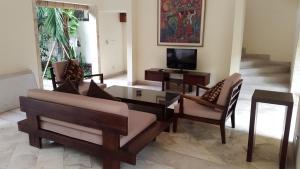a living room with a couch and a table and a tv at Villa Diana Bali in Legian