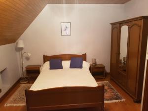 a bedroom with a bed with two blue pillows at Champagnac in Borrèze