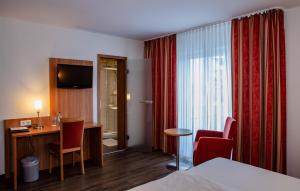 Habitación de hotel con cama y escritorio en Hotel Grauleshof en Aalen