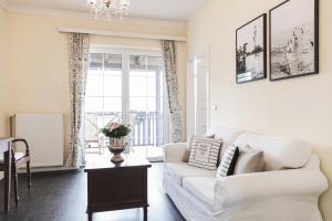 a living room with a white couch and a window at Strandhotel Sille in Reifnitz