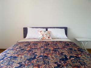 a bed with a colorful quilt and two pillows at Room in vacation home in Bar