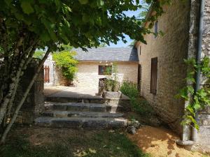 a stone house with stairs in front of it at Champagnac in Borrèze