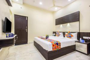 バンガロールにあるFabHotel Crown Suitesのベッドルーム(ベッド1台、デスク、テレビ付)
