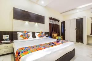 ein Schlafzimmer mit einem großen Bett in einem Zimmer in der Unterkunft FabHotel Crown Suites in Bangalore