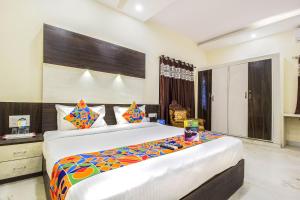 a bedroom with a large bed in a room at FabHotel Crown Suites - Nr Sony Signals in Bengaluru