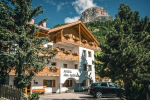un edificio con un'auto parcheggiata di fronte di Pension Merisana a Colfosco