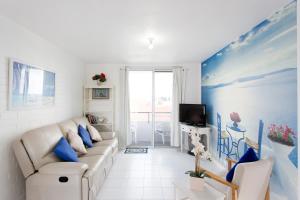 Il comprend un salon blanc doté d'un canapé et d'une télévision. dans l'établissement Ocean Harbour Views, à Fremantle