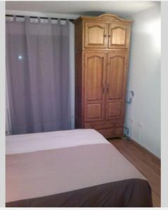 ブロトにあるCompleto Brotoのベッドルーム1室(ベッド1台付)、木製キャビネットが備わります。