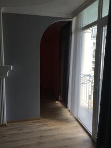 um quarto vazio com um corredor com uma grande janela em Apartment White Magnolia em Batumi