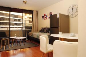 Habitación pequeña con nevera y mesa. en Apartamento Living Paris, en Santiago
