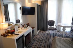 ein Hotelzimmer mit einem Schreibtisch und einem Tisch in einem Zimmer in der Unterkunft Seven Deep Hotel in Ankara