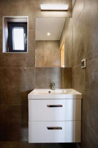 a bathroom with a white sink and a mirror at Sarbinowo Prestige - Ekskluzywne domki nad morzem in Sarbinowo