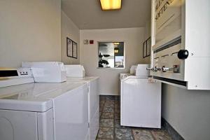 
a bathroom with a sink, toilet and a mirror at Hilltop Inn & Suites in Victorville
