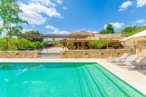 a swimming pool with chairs and a house at Sa Mata Grossa in Campanet