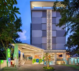 スマランにあるPOP! Hotel Pemuda Semarangの夜間にライトアップされたファサードを持つホテル
