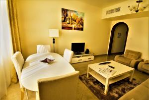 a living room with a white table and a couch at Abu Dhabi Plaza Hotel Apartments in Abu Dhabi