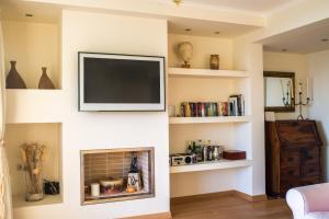 a living room with a tv above a fireplace at Modern Apartment with sea view in Saronida in Anavissos