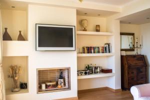 アナヴィソスにあるModern Apartment with sea view in Saronidaのリビングルーム(暖炉の上にテレビ付)