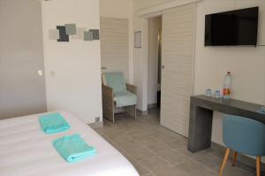 a bedroom with a bed and a desk and chairs at Villa La Terre Des Lauriers in Vallauris