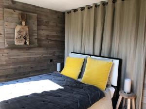 a bedroom with a bed with two yellow pillows at Ker Hazhou in Hédé