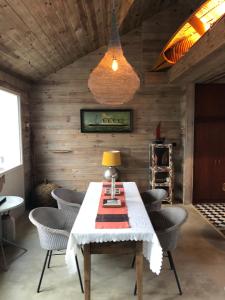 Ker Hazhou في Hédé: غرفة طعام مع طاولة بيضاء وكراسي