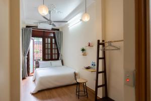ein Schlafzimmer mit einem Bett, einer Leiter und einem Fenster in der Unterkunft Nusmile's Homestay & Travel in Hanoi