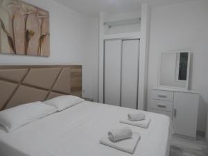 a bedroom with a white bed with two towels on it at Apartment Iv in Kotor