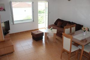 ein Wohnzimmer mit einer Couch und einem Tisch in der Unterkunft Vila Apartment in Poljica